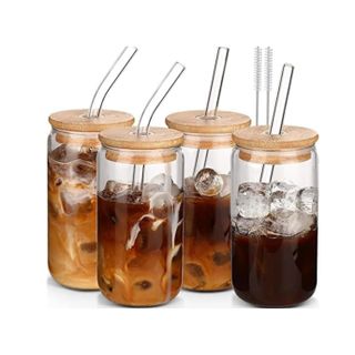 A set of four glass coffee cups with straws and lids