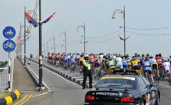 The peloton navigates its way safely onto a bridge