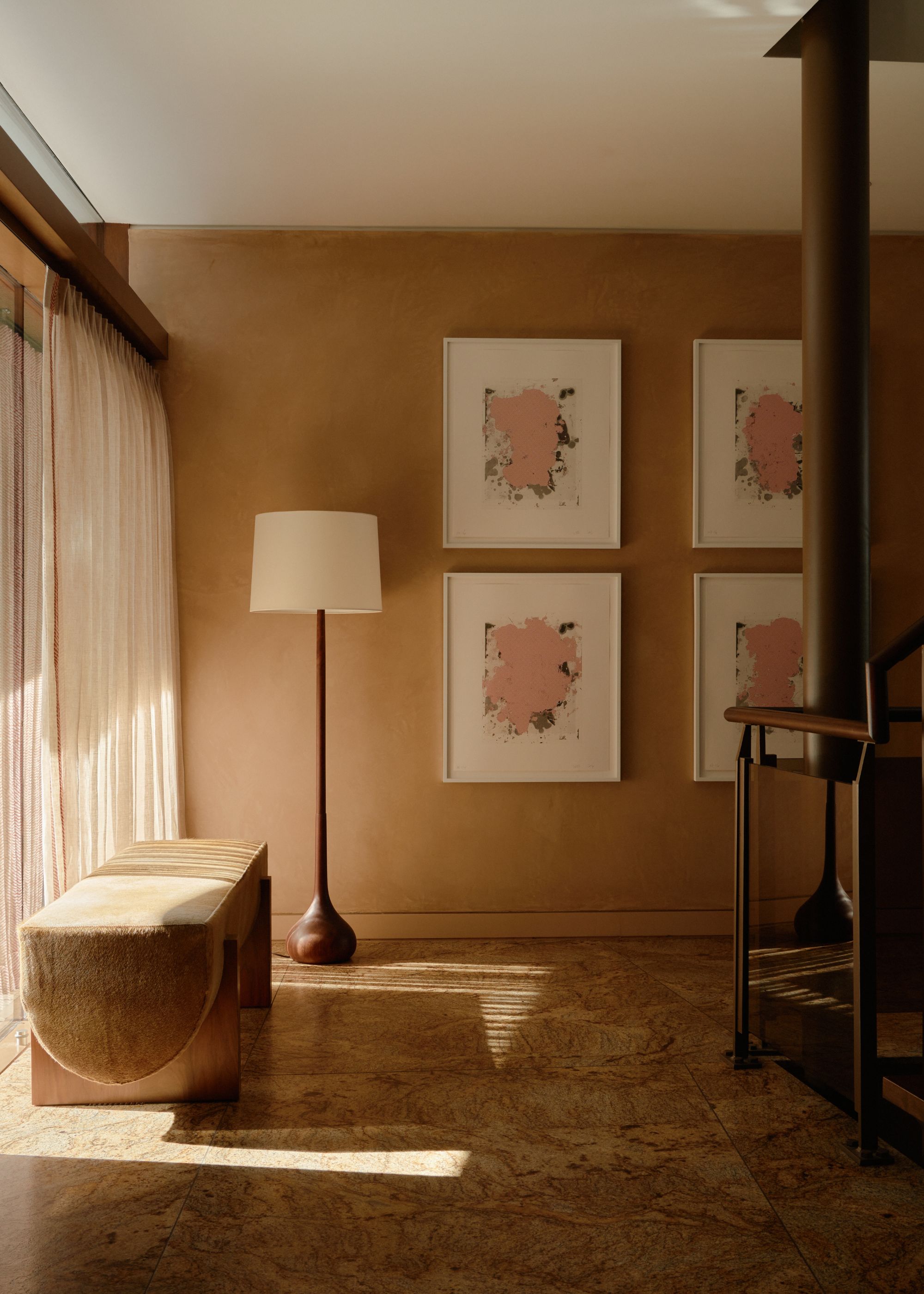 A hallway with sheer curtains, limewash walls and a standing lamp