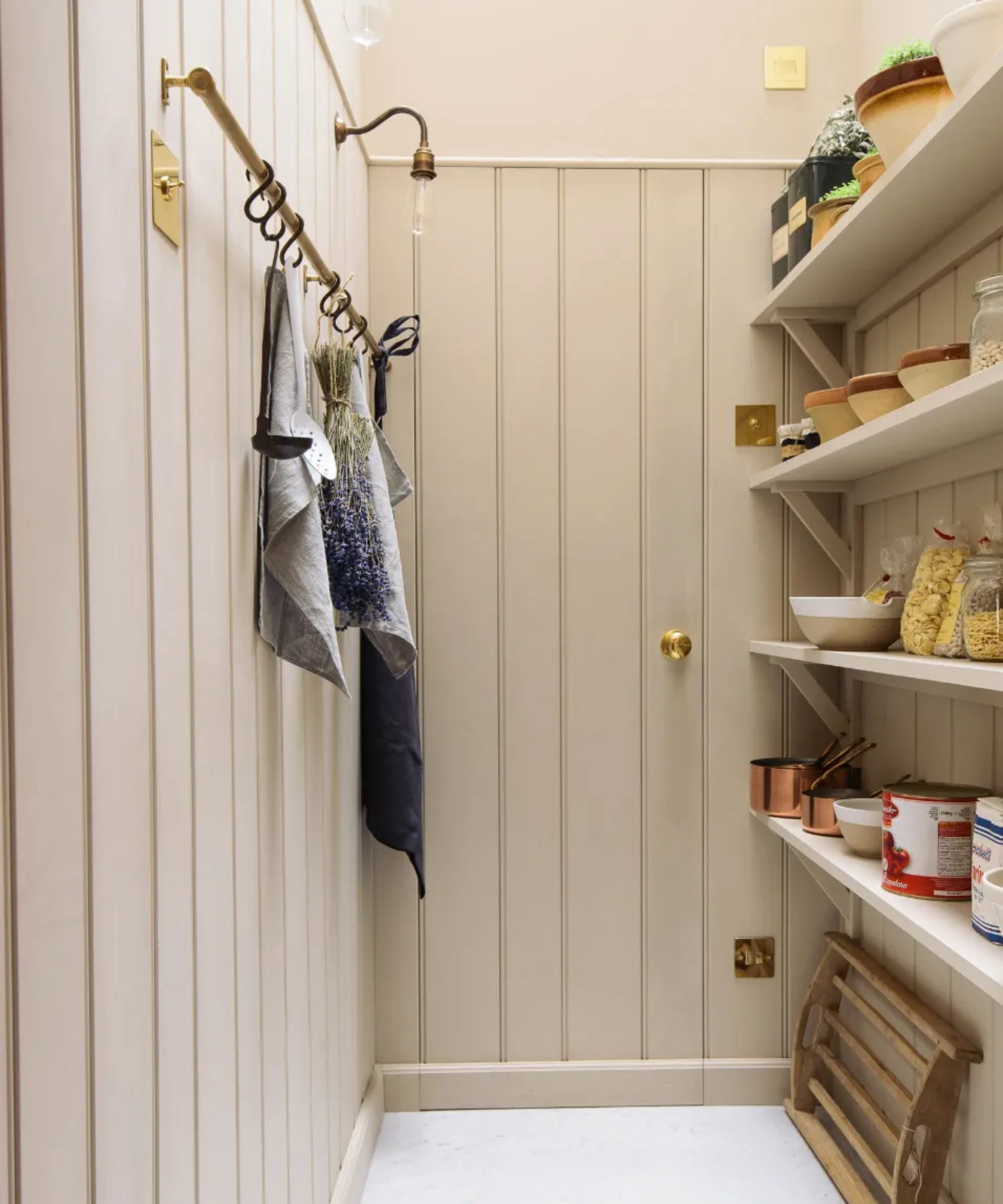 A walk in pantry space with a wood panelled door 