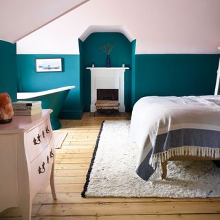 pink and teal bedroom with fireplace and freestanding bath