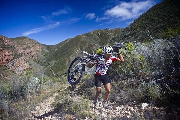 A Squirt team rider carries his bike.