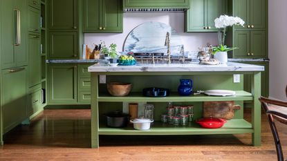 a green kitchen with storage on the island
