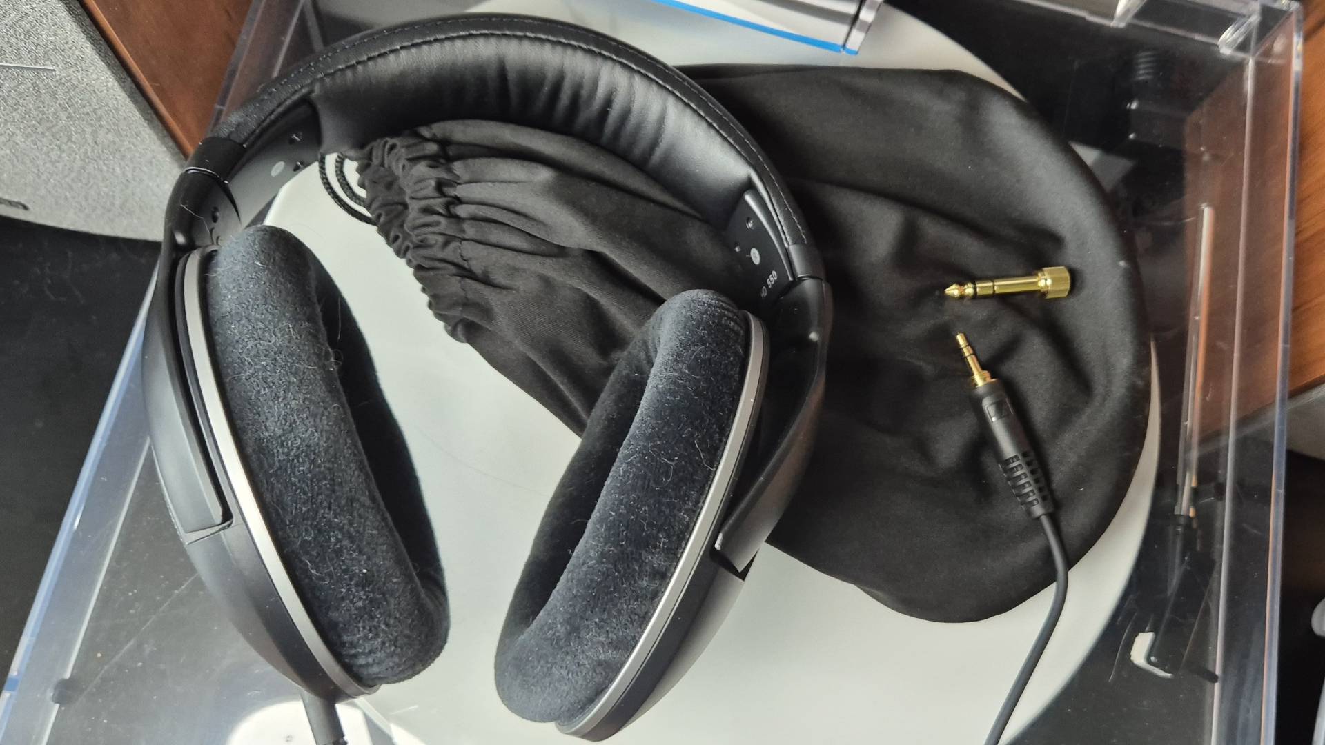 Photo taken by writer Rosalie Newcombe of the Sennheiser HD 550 headphones, and its accompanying carrying bag and jack adapter while sitting on a vinyl turntable.