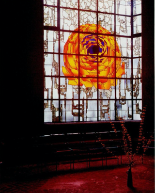 Interior view of the Pilgrimage Church. Stained glass window that lets in the light in the otherwise dark space. The stained glass window depicts a rose, in yellow, red, and blue.