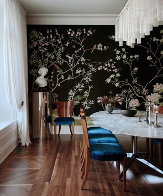 Dining room with mural in black behind marble table