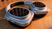 A pair of white headphones on a wooden table