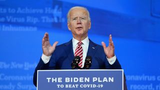 Biden stands at a podium with a sign on it that reads "The Biden Plan to Beat COVID-19"