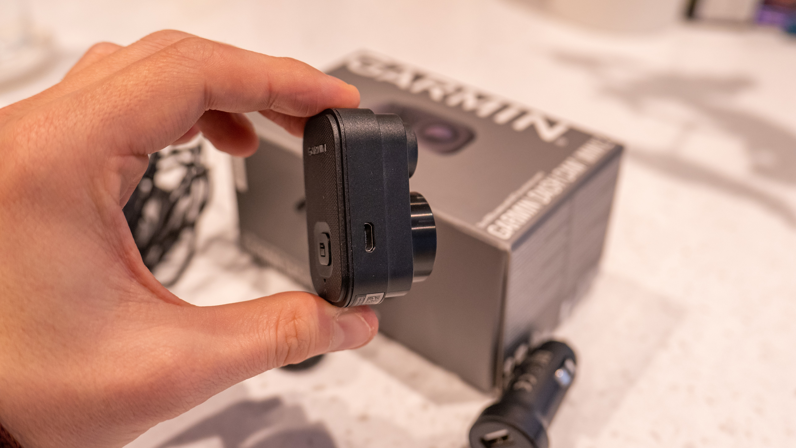 The Garmin Dash Cam Mini 2 next to its box on a table
