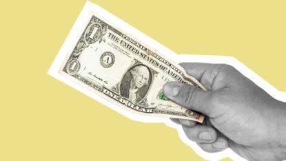 Hand holding a U.S. one-dollar bill against a yellow background