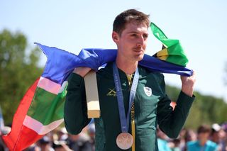 Bronze medallist Alan Hatherly of Team South Africa poses on the podium with his flag during the men's Cross-Country on day three of the Olympic Games Paris 2024