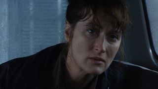 Meryl Streep sits in the passenger seat of a car in a rainstorm in The Bridges of Madison County