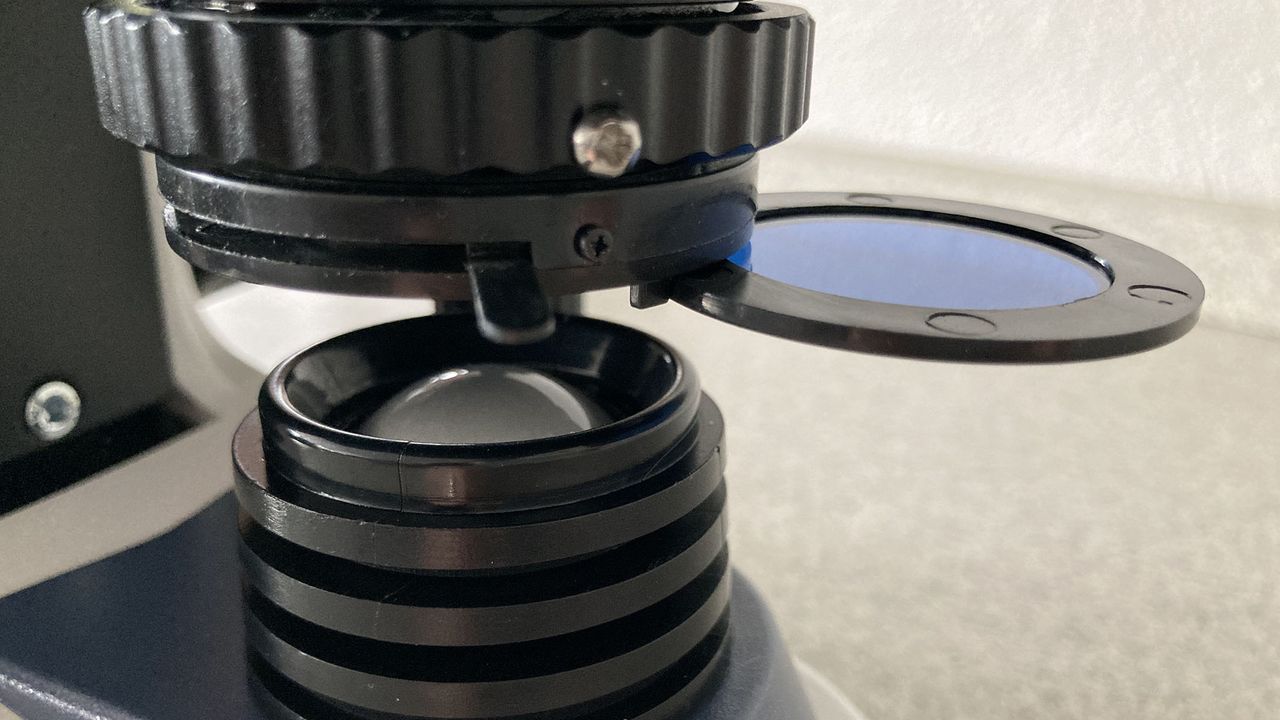The microscope's LED light being adjusted for brightness