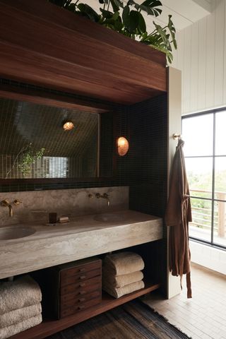 bathroom vanity in beige marble and dark green tiled backsplash