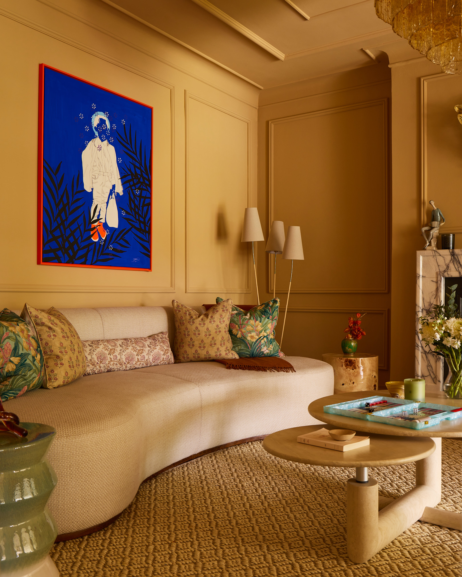 A mustard yellow living room with a striking blue piece of art on the walls