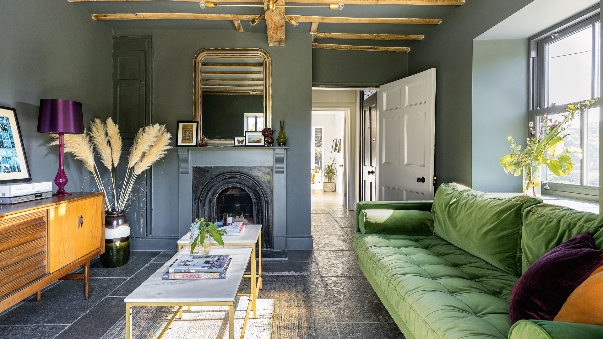 dark gray living room with woodwork painted the same color to show the how stylists decorate with dark colors