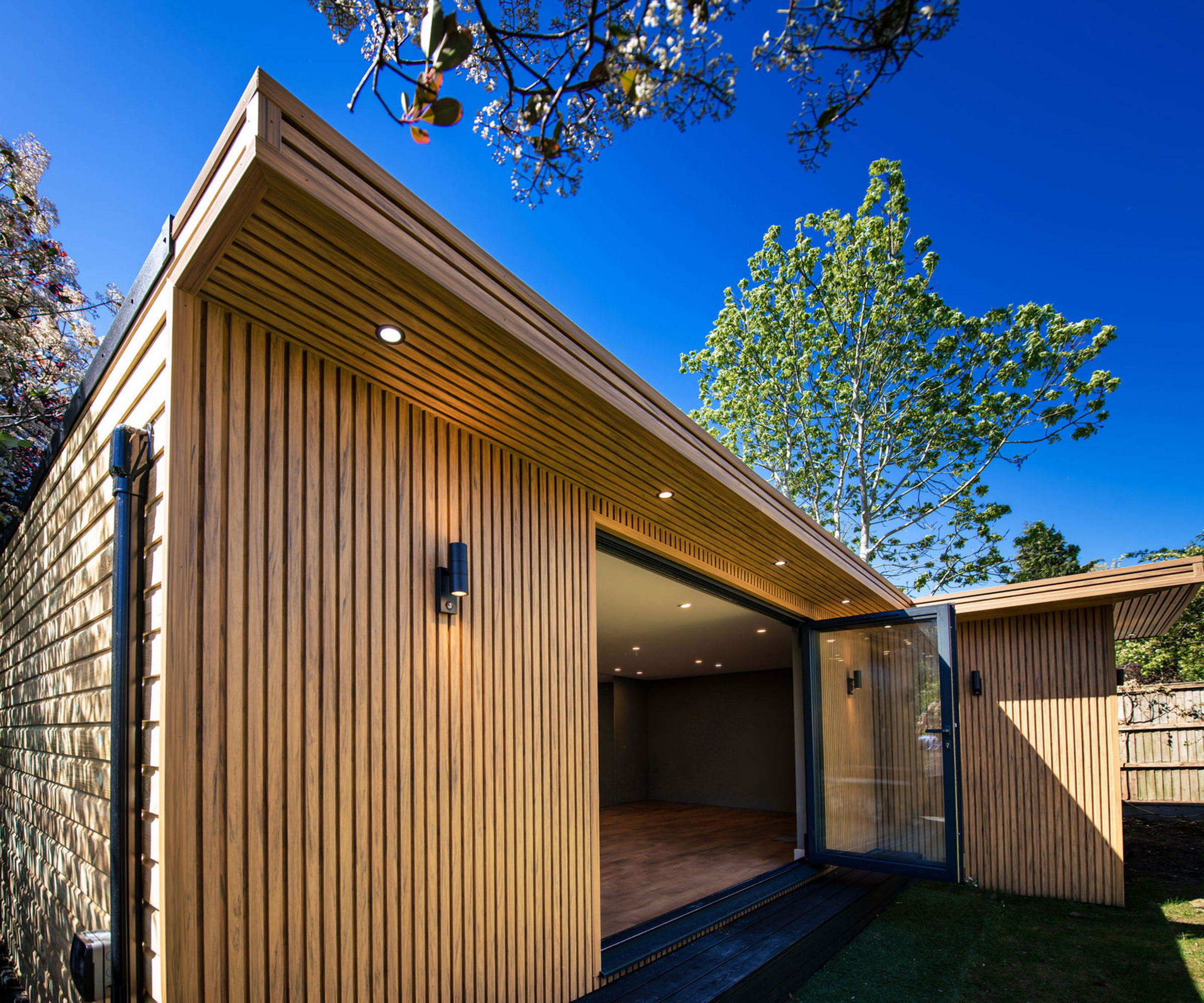 garden room building clad in slatted timber