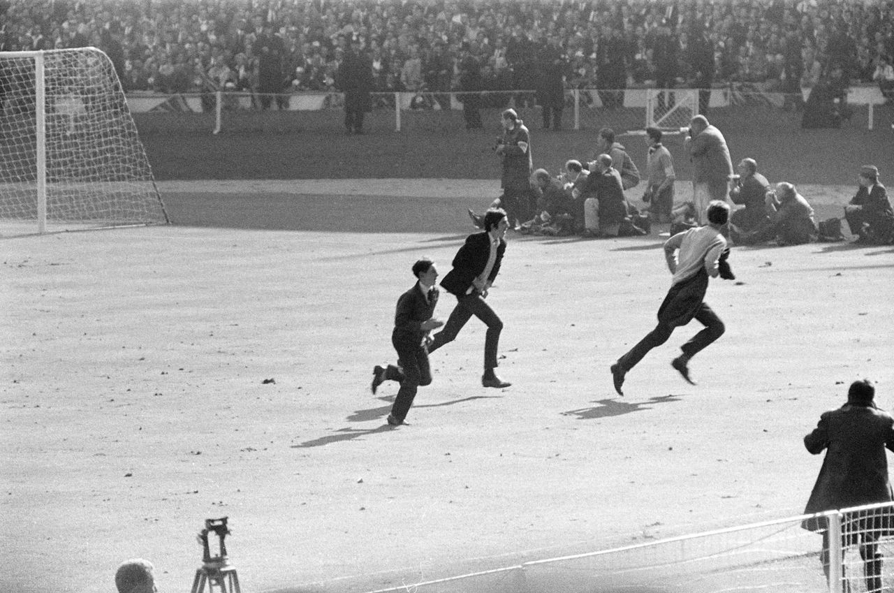 England fans run onto the pitch in the last seconds of the 1966 World Cup final at Wembley, prompting commentator Kenneth Wolstenholme to utter his famous "They think it's all over!" line