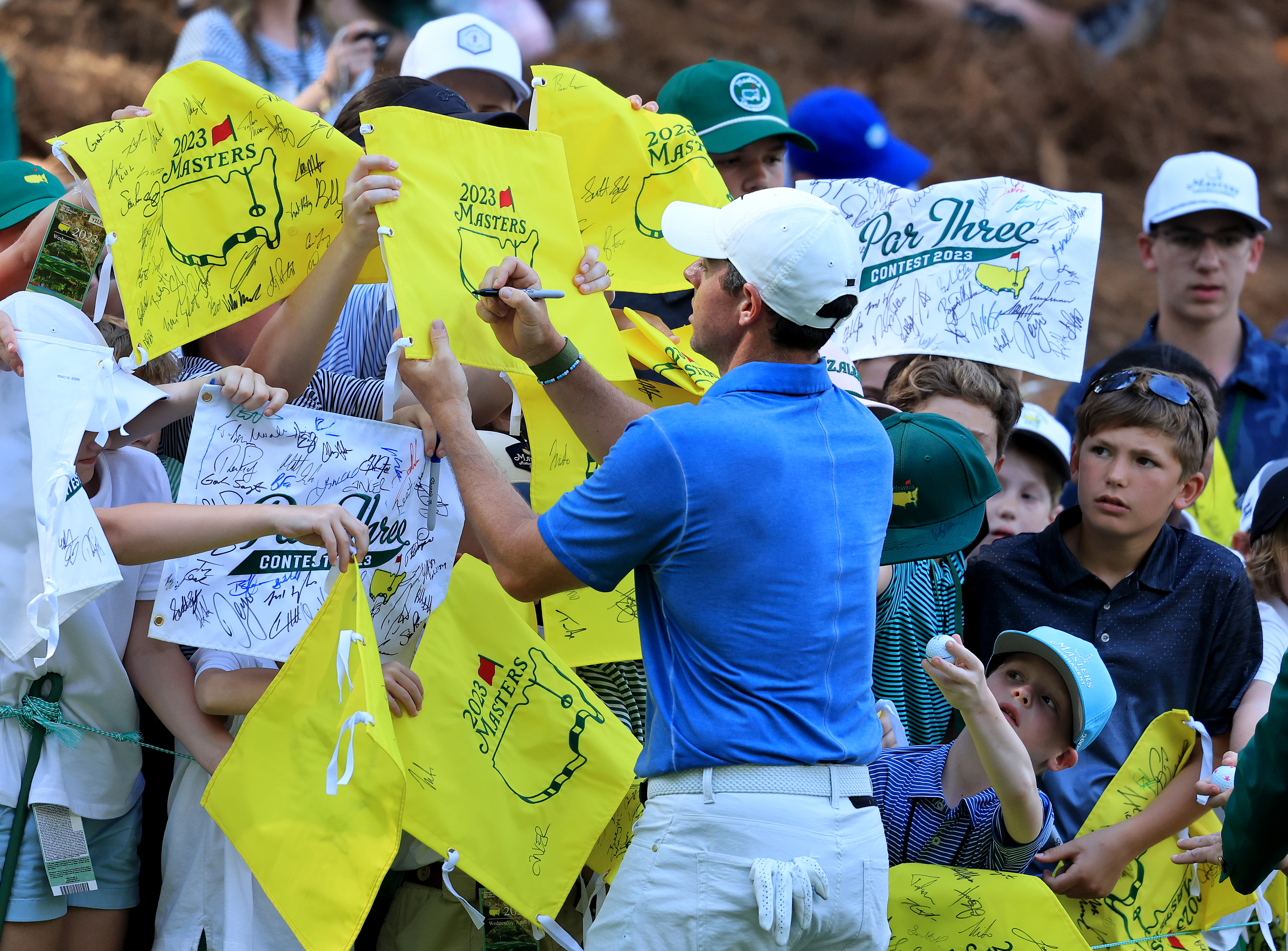 Rory McIlroy signing fans' yellow Masters flags