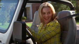 Alicia Silverstone smiles while sitting behind the wheel of her Jeep in Clueless.