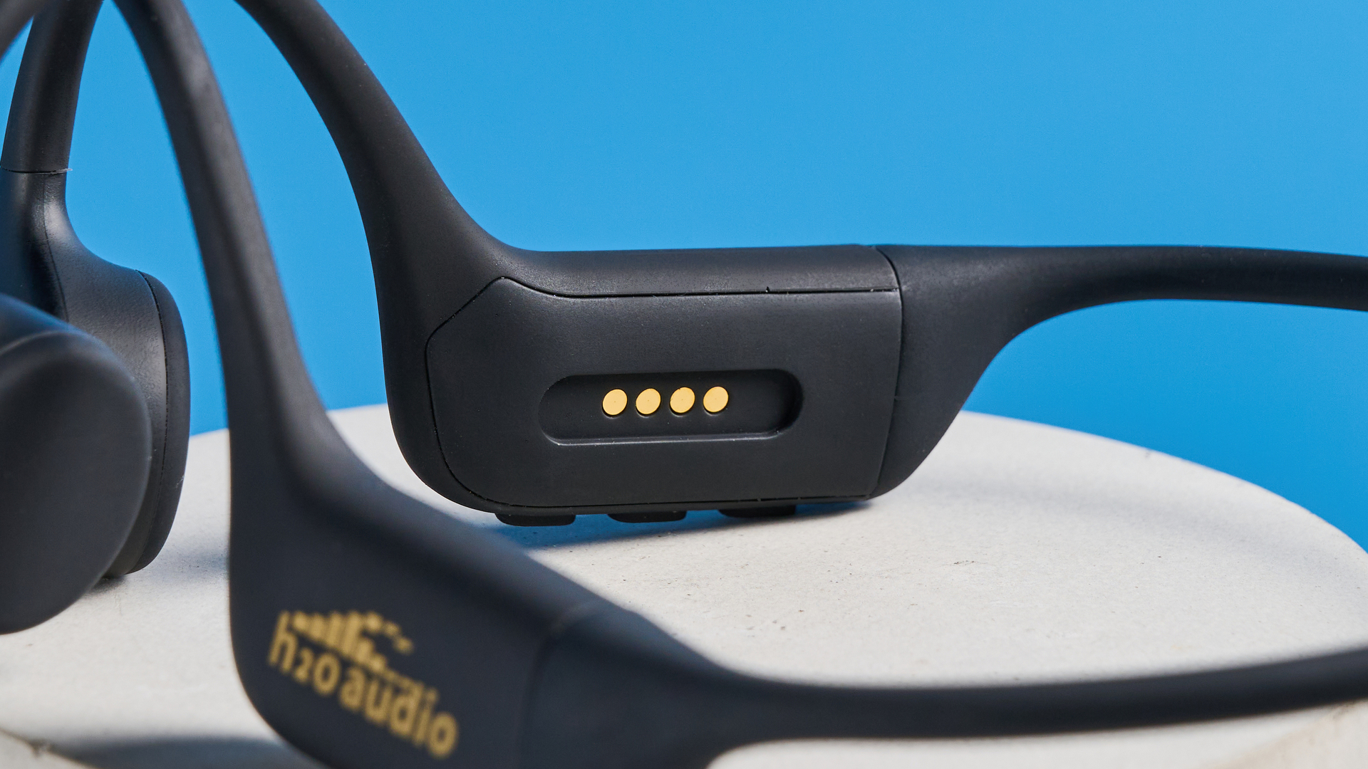 H2O Audio TRI 2 PRO headphones photographed in front of a blue background