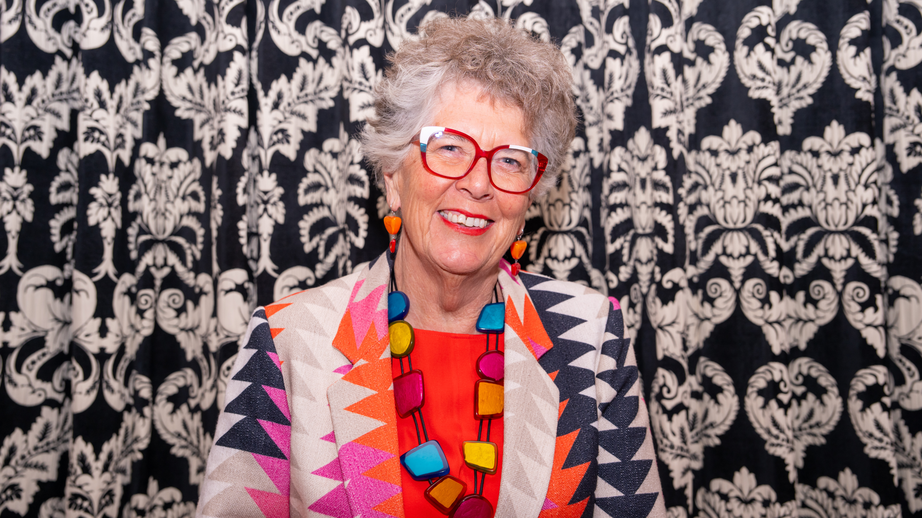 Prue Leith in colourful geormetric suit at Cambridge university.