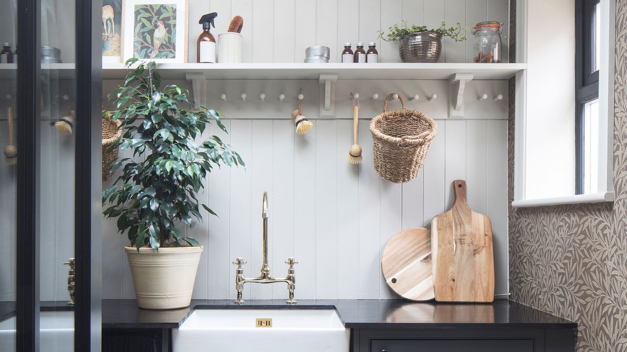 Utility room with dark grey cabinetry, wall panelling and wallpaper