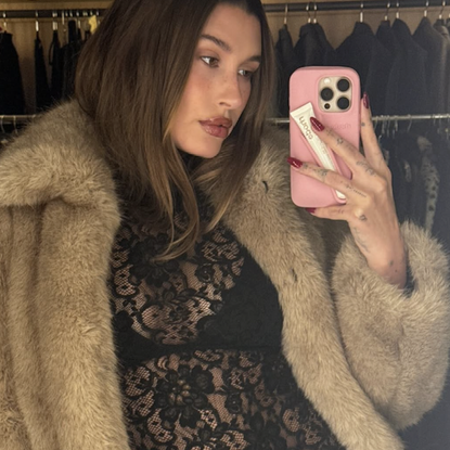 hailey bieber wears a fur coat and black lace top that showed her bra