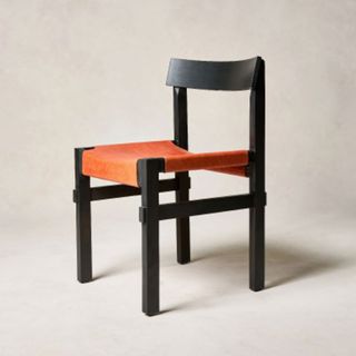 Japandi style dining chair with black wooden frame and blood orange leather seat