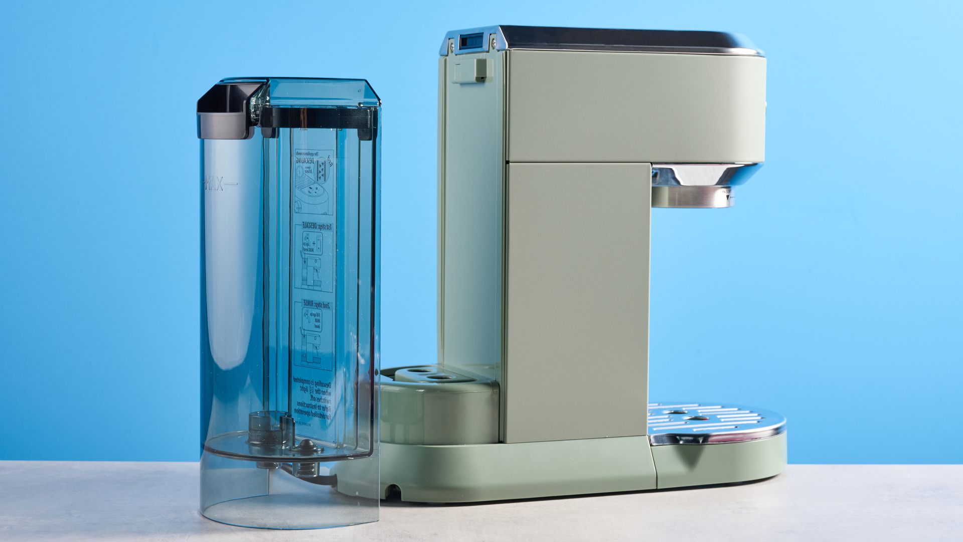 DeLonghi Dedica Duo in the green colorway with accessories photographed on a blue background.