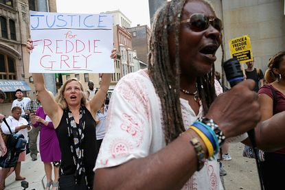 Demonstrators protest outside pre-trial hearings for Baltimore police officers charged in Freddie Gray's death