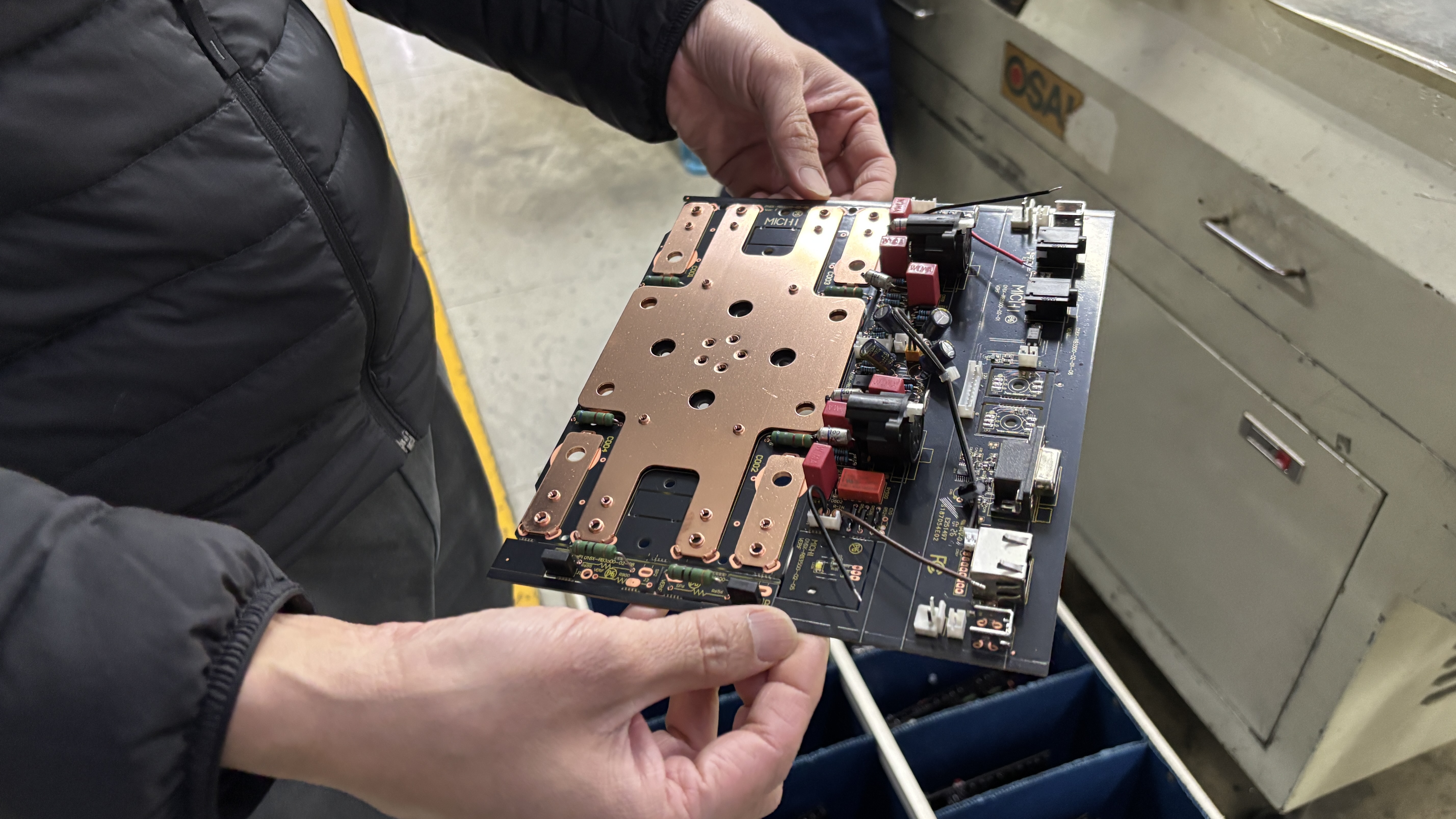 Man holding a circuit board for a Rotel Michi hi-fi product