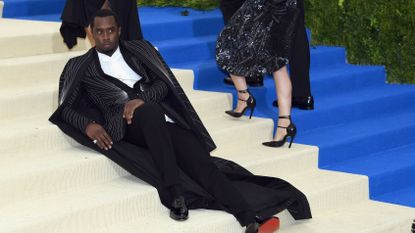 Diddy lays on a carpeted staircase posing for the press.