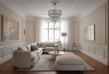 a living room with pink walls and a murano glass chandelier