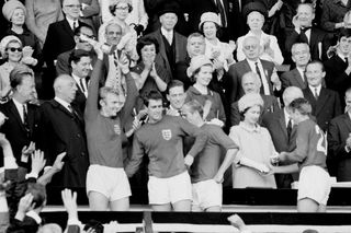 Hunt received a medal from the Queen while captain Bobby Moore celebrated after the 1966 final