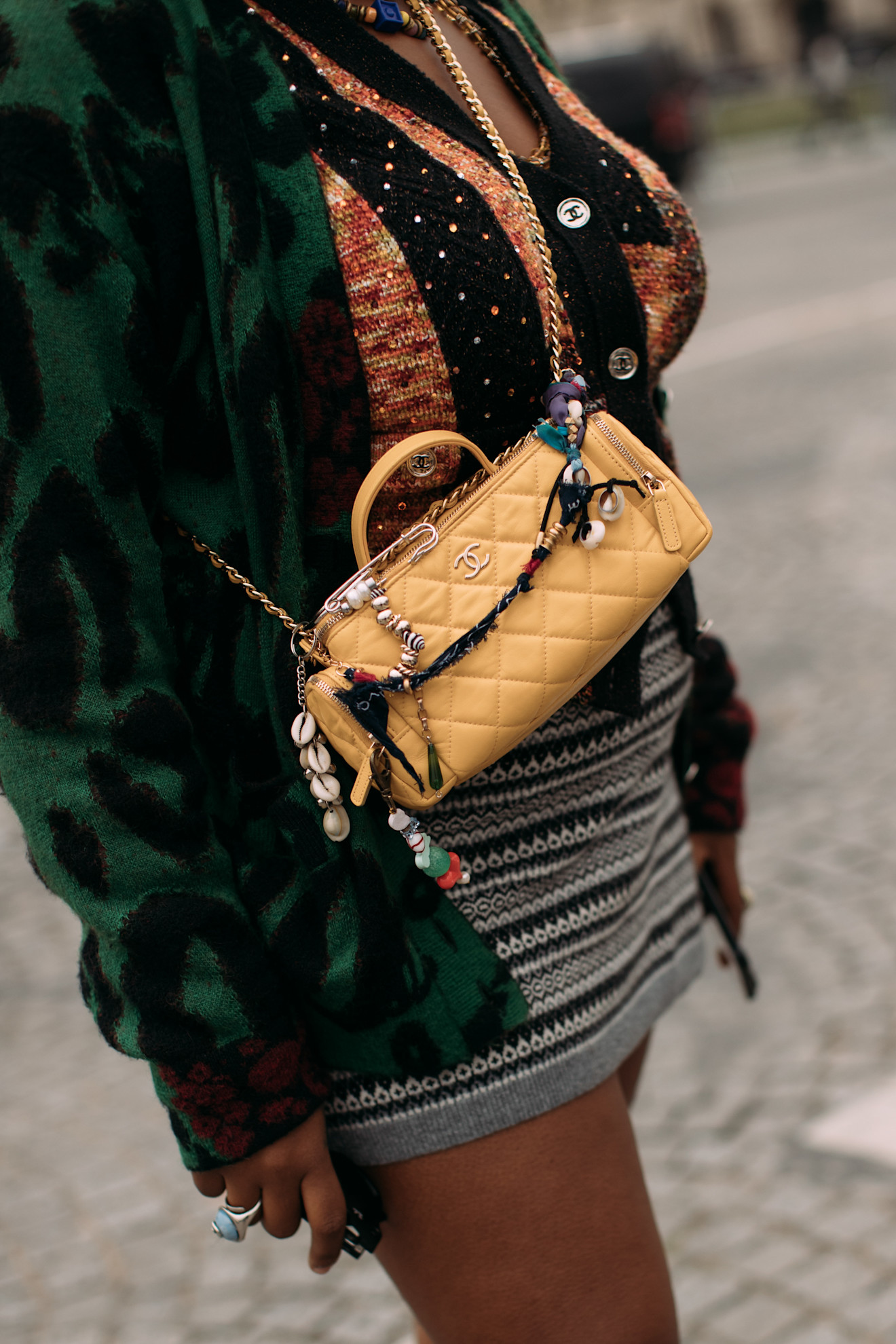 a close up of a yellow chanel quilted bag with charms