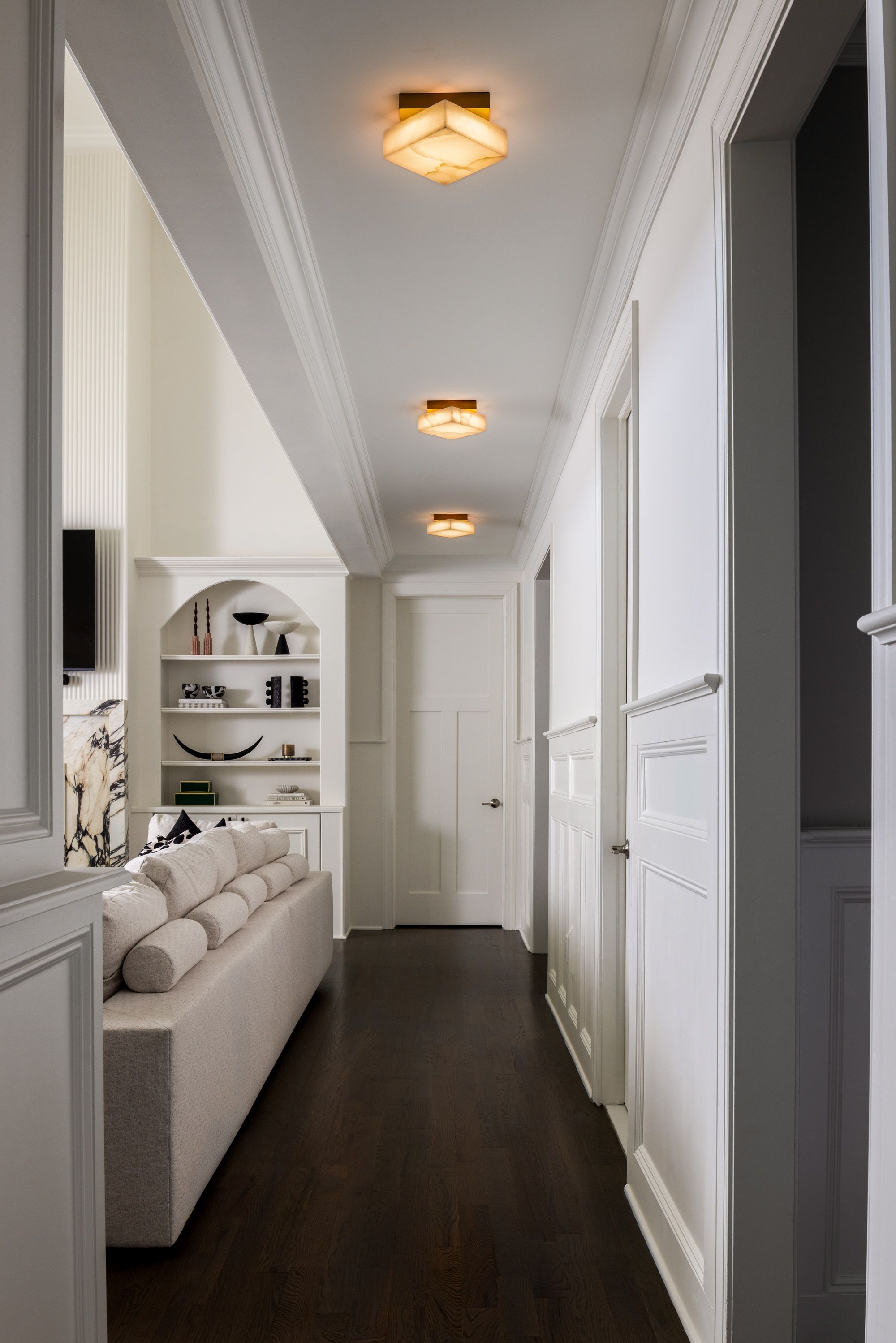 a hallway with modern geometric ceiling lights glowing
