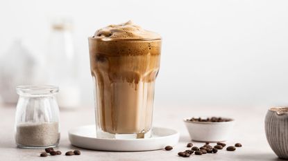 how to make a mocha coffee - a mocha coffee on a countertop with coffee beans and sugar around it