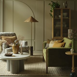 A living room with a green Habitat sofa and a Morris Co armchair