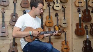 Man playing ukulele in a guitar store