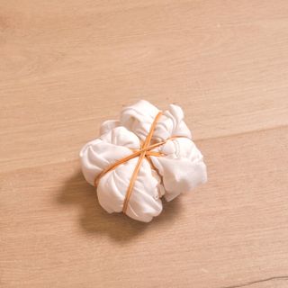 white napkin and rubber band on wooden flooring
