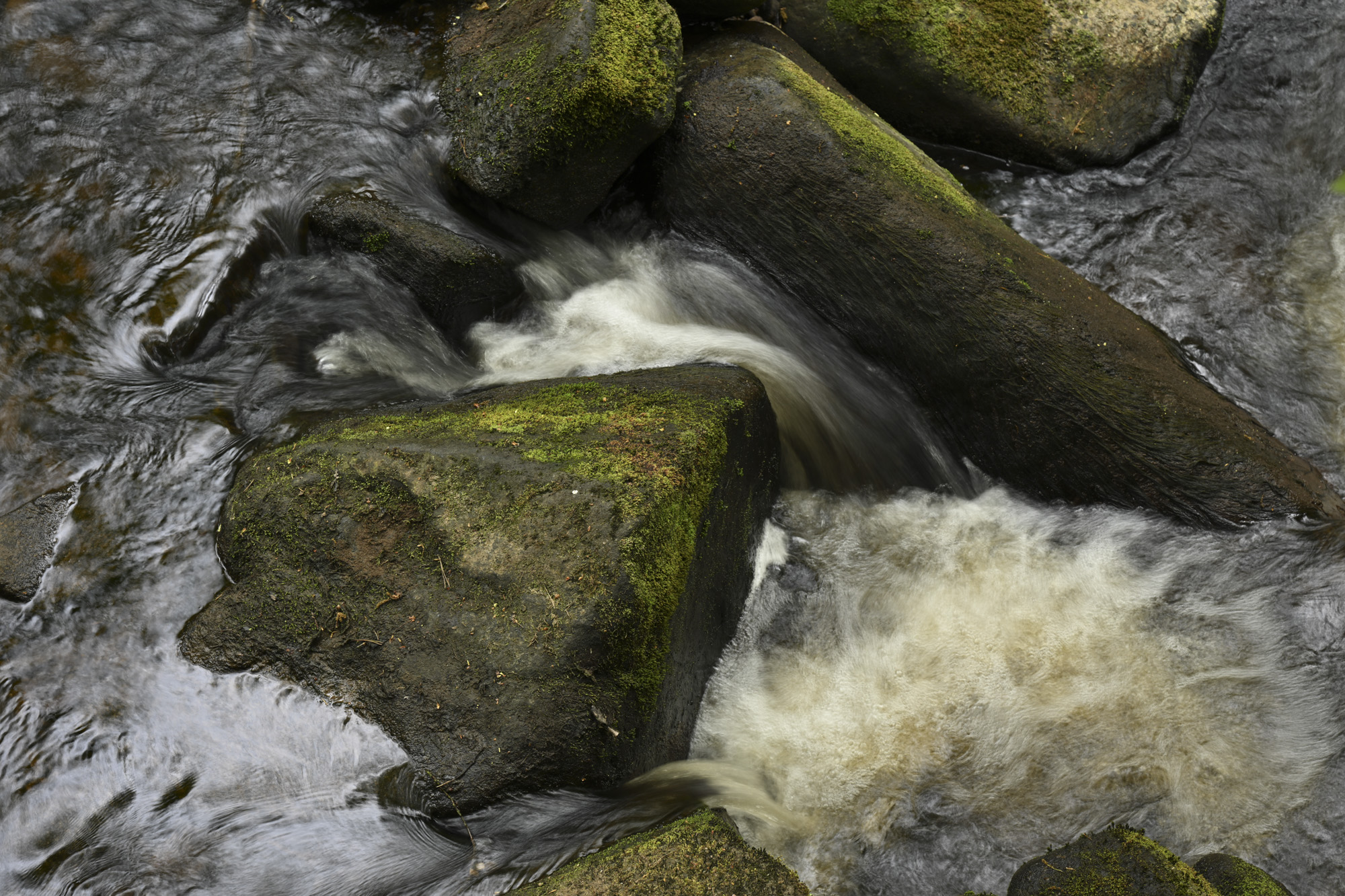 Closeup of a stream and rocks with motion blur in the moving water