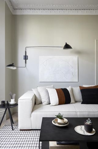 grey living room with white sofa and black and white area rug
