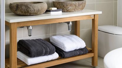 Linen cupboard with folded towels and labelled storage baskets