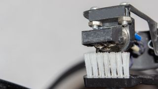 A small brush cleaning the stylus of a turntable