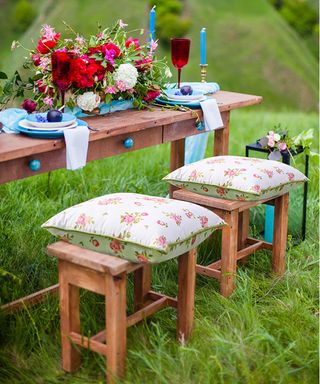Outdoor birthday party ideas with wooden stools and cushions