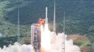 A large rocket launching from a scaffolding tower in the jungle