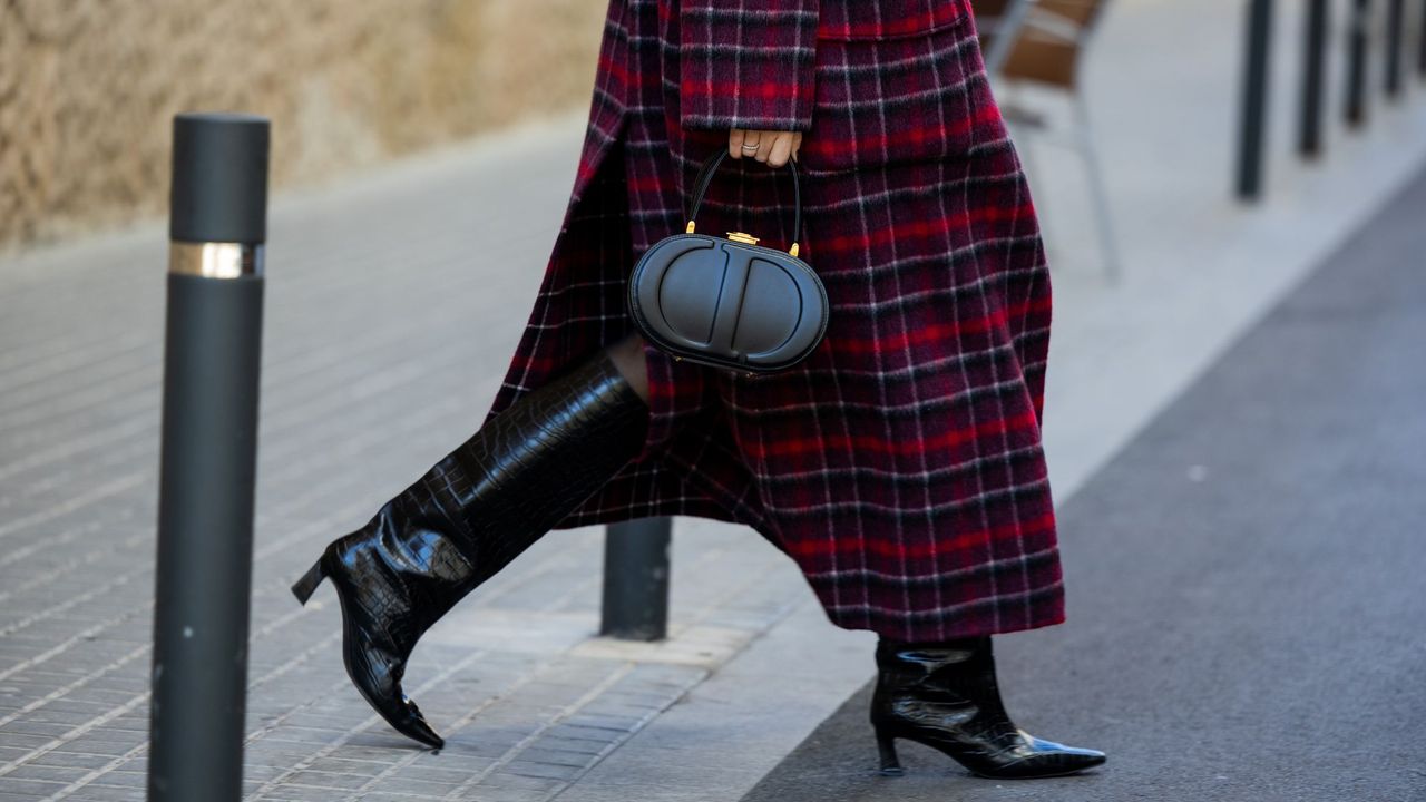 Miss Dior Perfume Cyber Monday: A woman wearing a checkered coat, black leather boots and a black Dior handbag