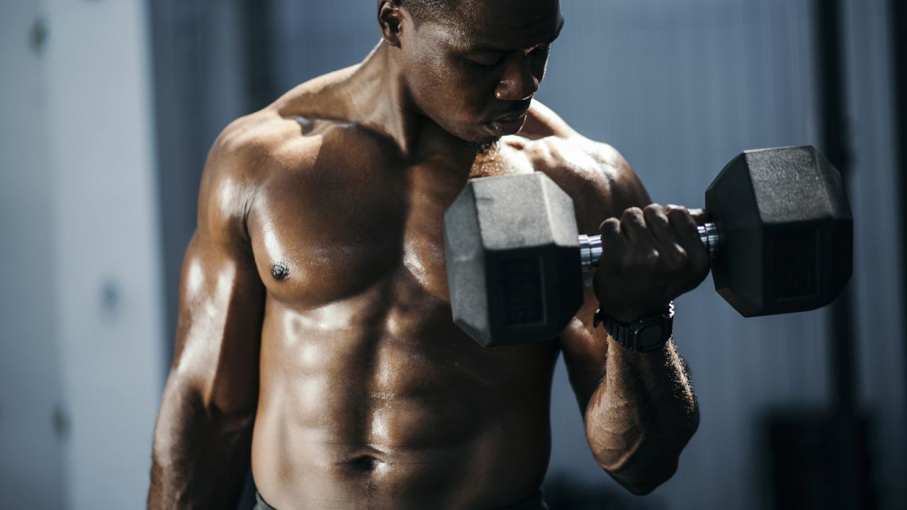 Musclular person lifting dumbbells