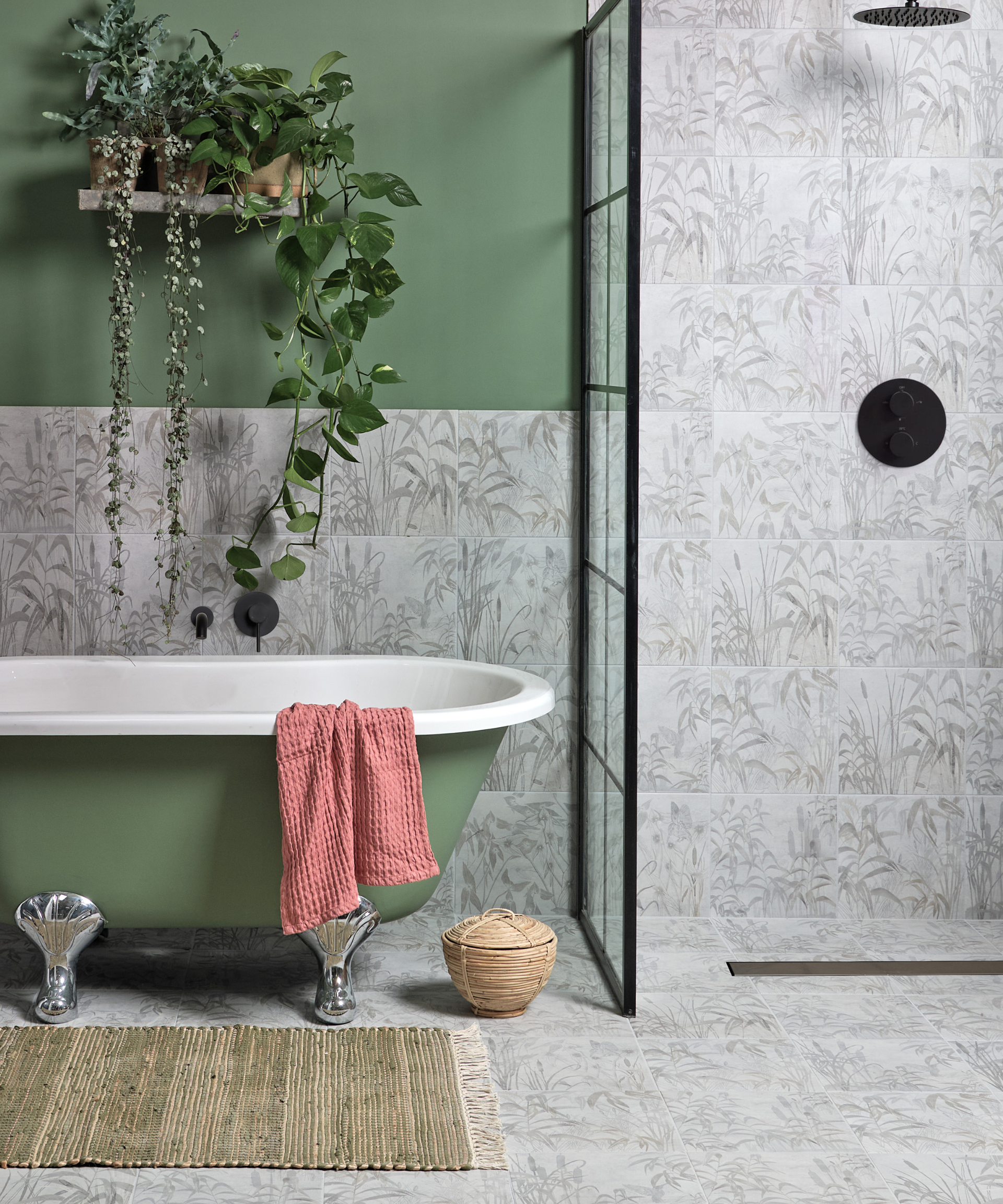 A gray bathroom with a green bathtub and a plant.